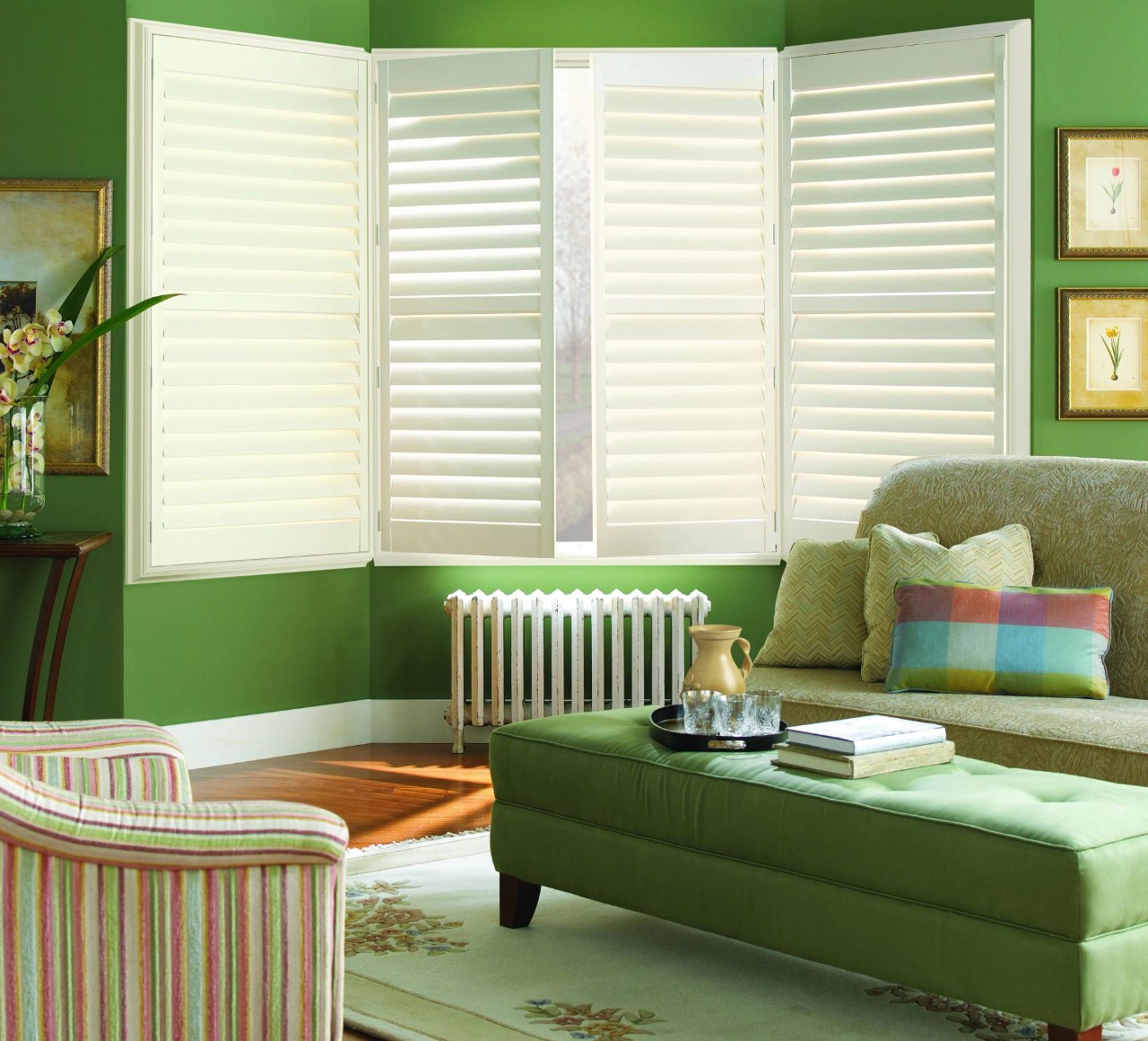 Hunter Douglas Palm Beach™ Polysatin™ Vinyl Shutters providing color contrast in a green Wichita, KS, living room