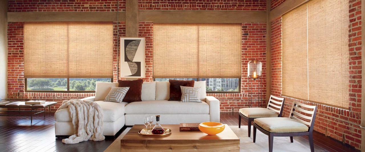 Brick living room with white couch and Provenance Woven Wood Shades.